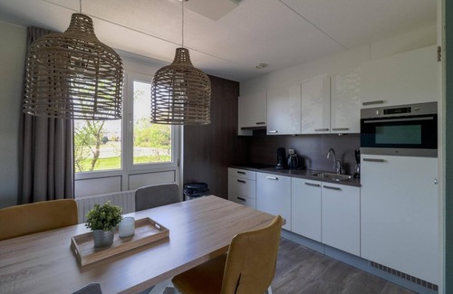 Makkum House | 4-person Schakel Deluxe bungalow with a view of the water, spacious yard, and modern kitchen at Beach Resort Makkum on the IJsselmeer.