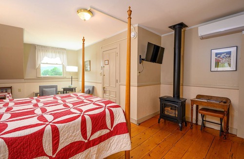 Stowe Bed & Breakfast | Comfortable room with queen bed and daybed with windows on 3 sides, a stunning view of Mount Mansfield and a parlor stove with full service breakfast included