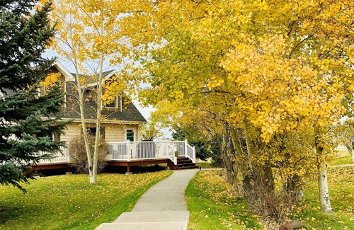 Bozeman House | Falls Queen Suite with vaulted ceilings, mountain views and property hot tub.