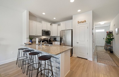 Thomas Drive House | Modern 3BR Townhome | Pool Access | Near Publix Sports Park & Beaches | Sleeps 9