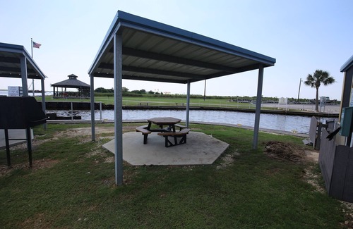 Sabine Pass Cottage | Park your boat in front of the Fishermen's Cottage! Screened in patio.