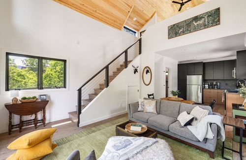 Young Harris Cabin | Romance meets design at Viking Hut, a Scandinavian 1BR retreat in the North Georgia mountains. Floor-to-ceiling windows frame fiery fall leaves, a skylight invites stargazing from your king bed, and a fenced yard makes it perfect for pups.