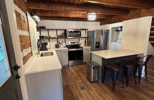 Manchester Cabin | Stunning hand-hewn log cabin blending rustic charm with modern comfort. Minutes from Manchester's dining & shops, yet secluded enough to truly relax. Warm timber beams, cozy furnishings, smart TV & spacious living. 4 bedroom, sleeps 12.