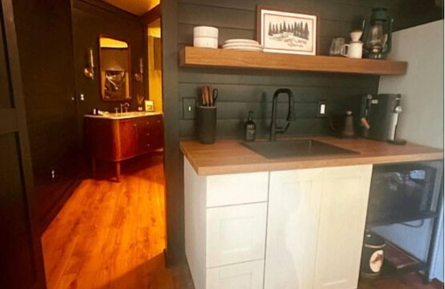 Mill Spring RV Rental | The Dogwood - Glamping tent with 1 King bed for 2 adults. En suite bathroom, kitchenette, and open porch.