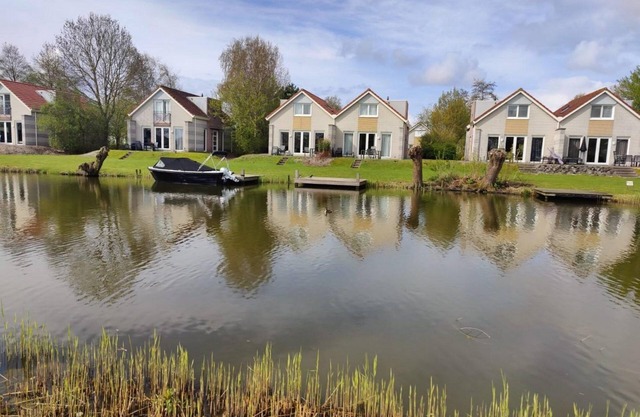 4-person Schakel Deluxe bungalow with a view of the water, spacious yard, and modern kitchen at Beach Resort Makkum on the IJsselmeer.
