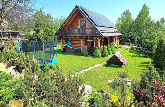 A beautiful wooden house with a sauna and jacuzzi and a large garden.