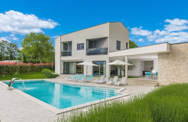 A modern luxury villa with a crystal-clear swimming pool and cultivated garden