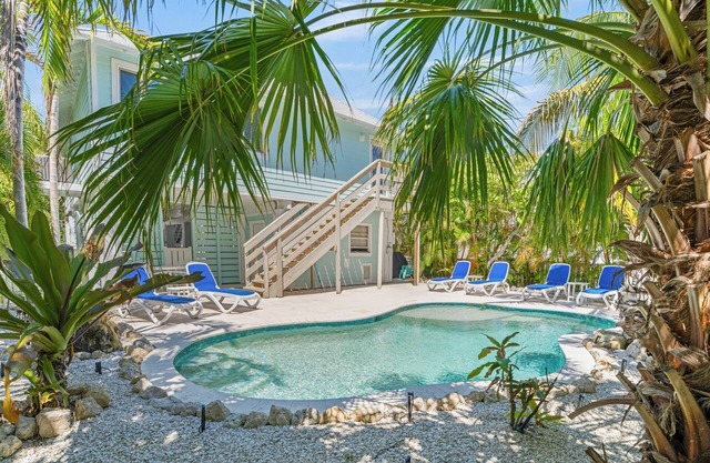 Charming cottage with heated pool, tropical landscaping in prime location.