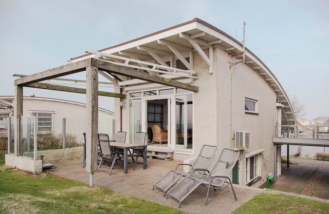 Detached Dijkvilla with a panoramic view of the IJsselmeer, private wellness facilities, and a large patio at the luxurious Beach Resort Makkum.