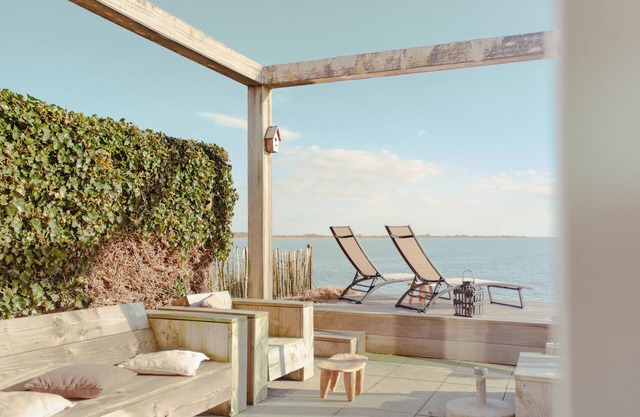 Detached Dijkvilla with a large patio, a panoramic view of the IJsselmeer, and three bedrooms at the luxurious Beach Resort Makkum.