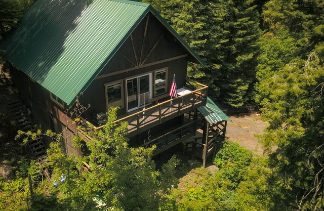 Mountain chalet nestled in the evergreens, peekaboo views of the lake in between