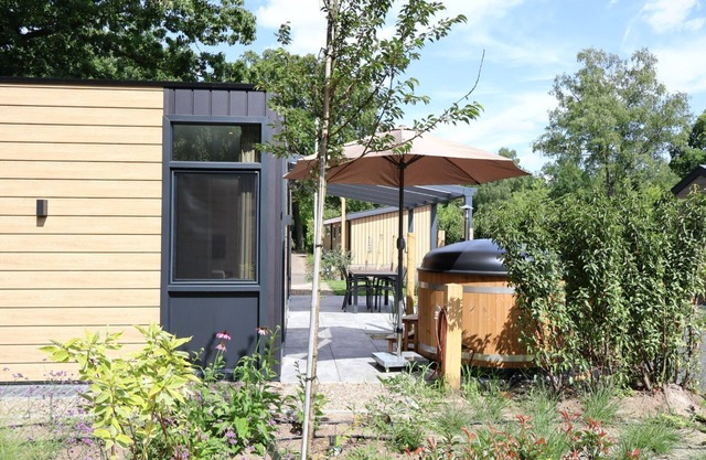 osendael: Stylish 4-person home with 2 bedrooms, each with en-suite bathrooms—one with a whirlpool and the other with a shower and sunshower—a hot tub, partially covered outdoor terrace, and modern kitchen. Enjoy luxury in the Veluwe!