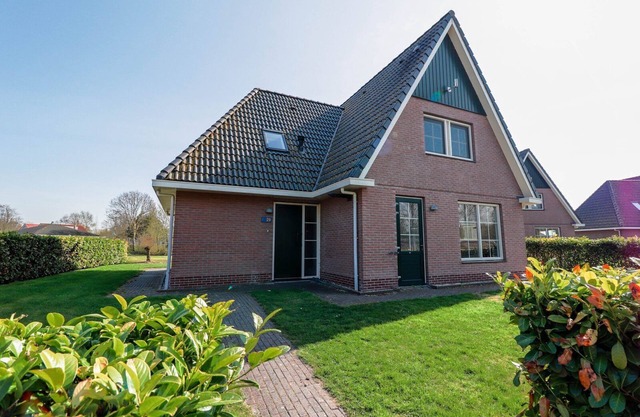 Spacious Beachvilla for 12 people with six bedrooms, a double walk-in shower, and a large yard at Beach Resort Makkum.