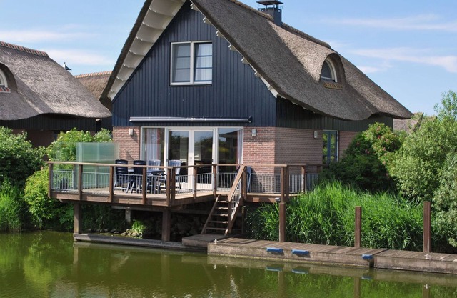 Thatched villa with terrace on the water at a holiday park in Friesland