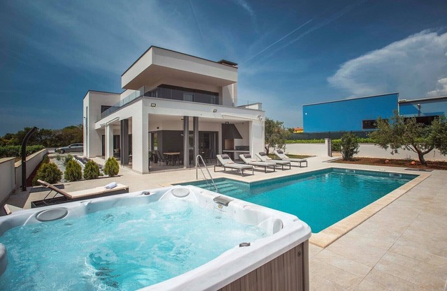 This villa with pool is surrounded by nature and offers tennis court.