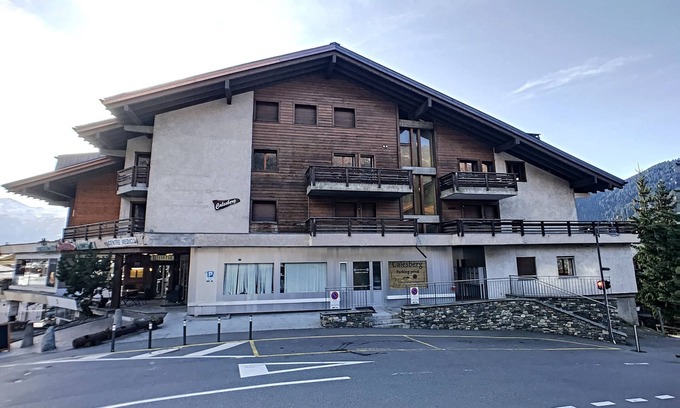 Verbier Apartment | An entrance with a guest toilet, a spacious living room with fireplace and TV corner, an open kitche