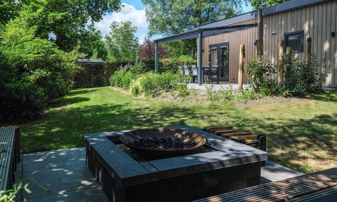 Lieren House | Enjoy a luxurious holiday home for 4 people in the wooded nature of the Veluwe, complete with modern amenities, air conditioning, a stylish pergola, and a cozy lounge area with an outdoor fireplace for ultimate comfort and ambiance, both day and nigh