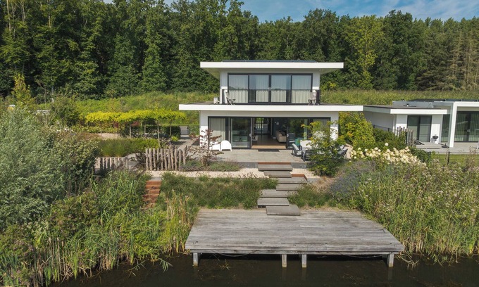 Zeewolde House | Luxury 6-person villa with private infrared sauna, outdoor shower, balcony with water views and sunny fenced garden with private dock. Located at Villa Resort Harderwold.