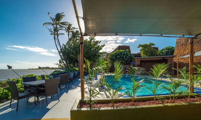 Kaunakakai House | Your Ultimate Oceanfront Retreat | Relaxing Room with Lush Garden View